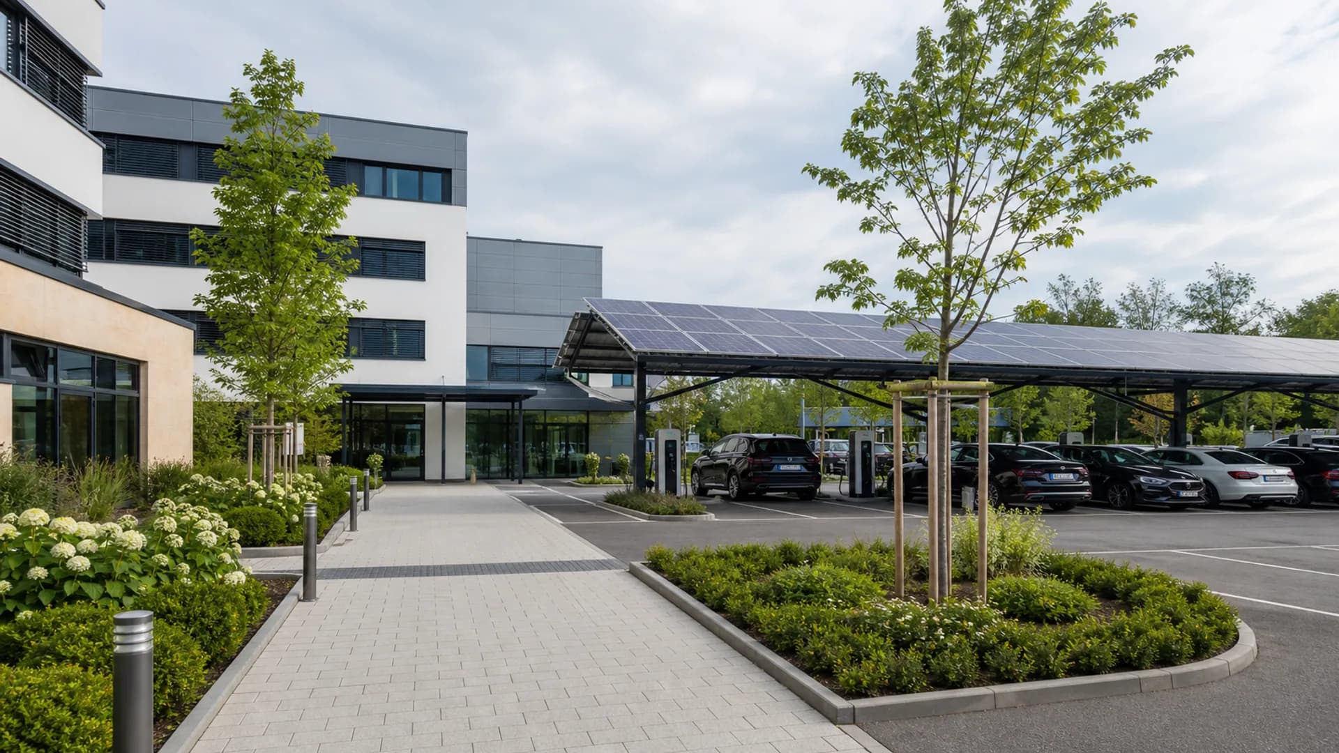 Visualisierung eines ruhigen Klinik-Eingangsbereichs mit Solarcarport und Ladepunkten.