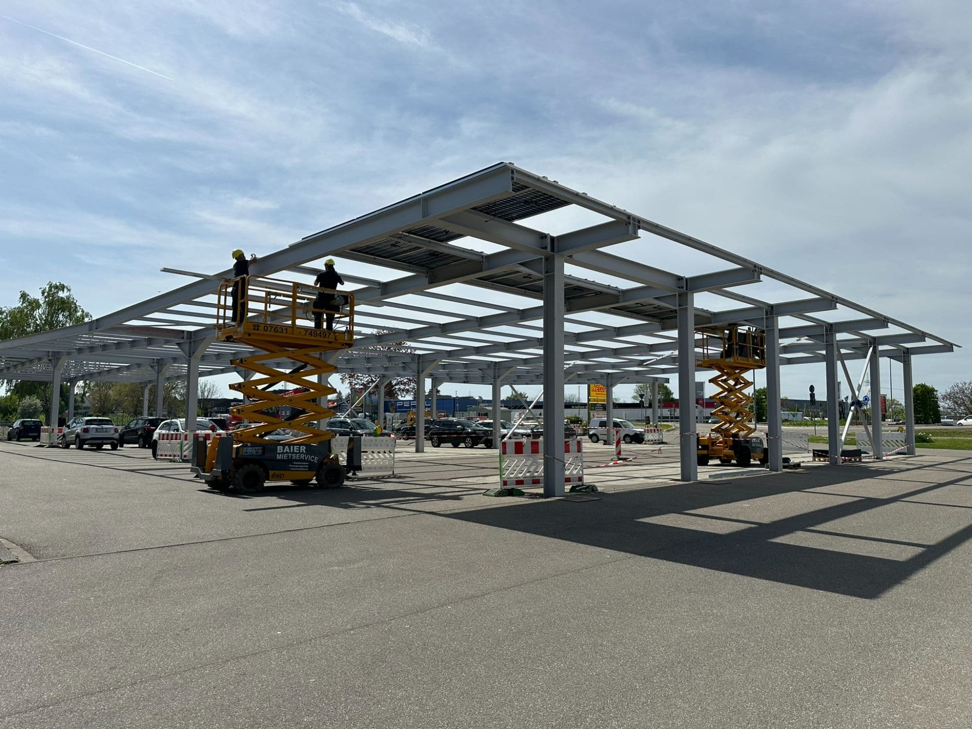 Bauphase des Ladeparks Auggen mit Stahlkonstruktion und PV-Modulmontage.