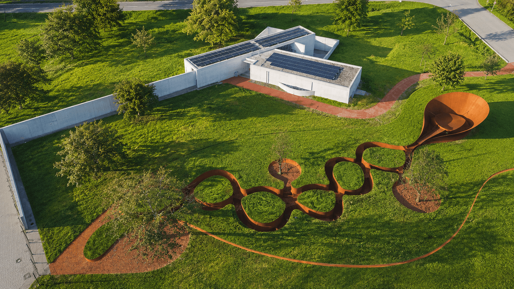 Luftbild des Doshi Retreat auf dem Vitra Campus mit Solardach und geschwungener Korten-Stahl-Struktur